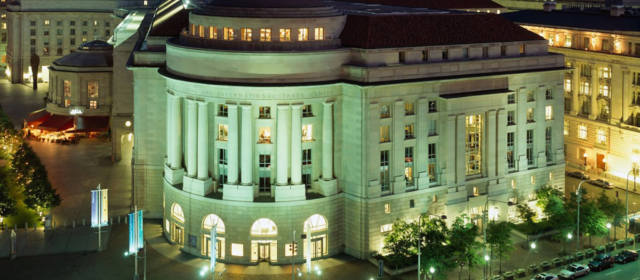 Night shot of green-lit governmental-style building with rotunda