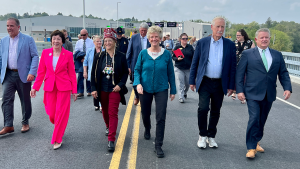 Group of people walking over a bridge.