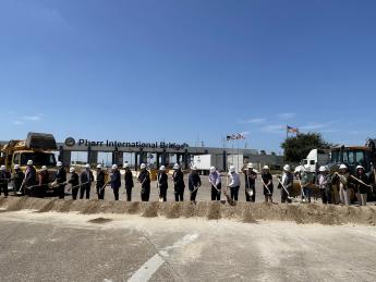 Group of about 20 people with shovels in their hands break ground at the LPOE to celebrate the beginning of the project.