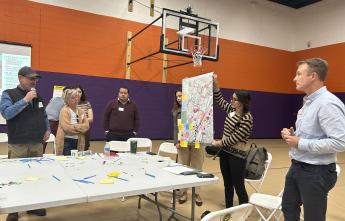 variety of men and women standing around table during thought provoking discussion excercises