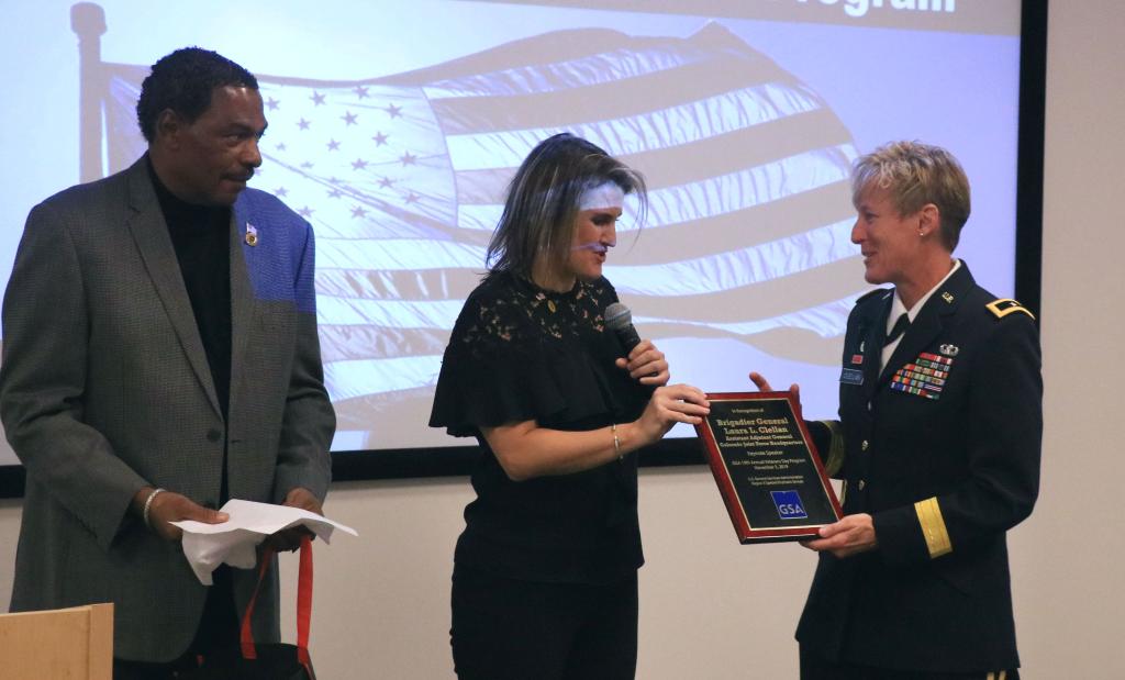 James Foster (Left) and Katie Gates present Brig. Gen. Laura Clellan with a token of appreciation from GSA.