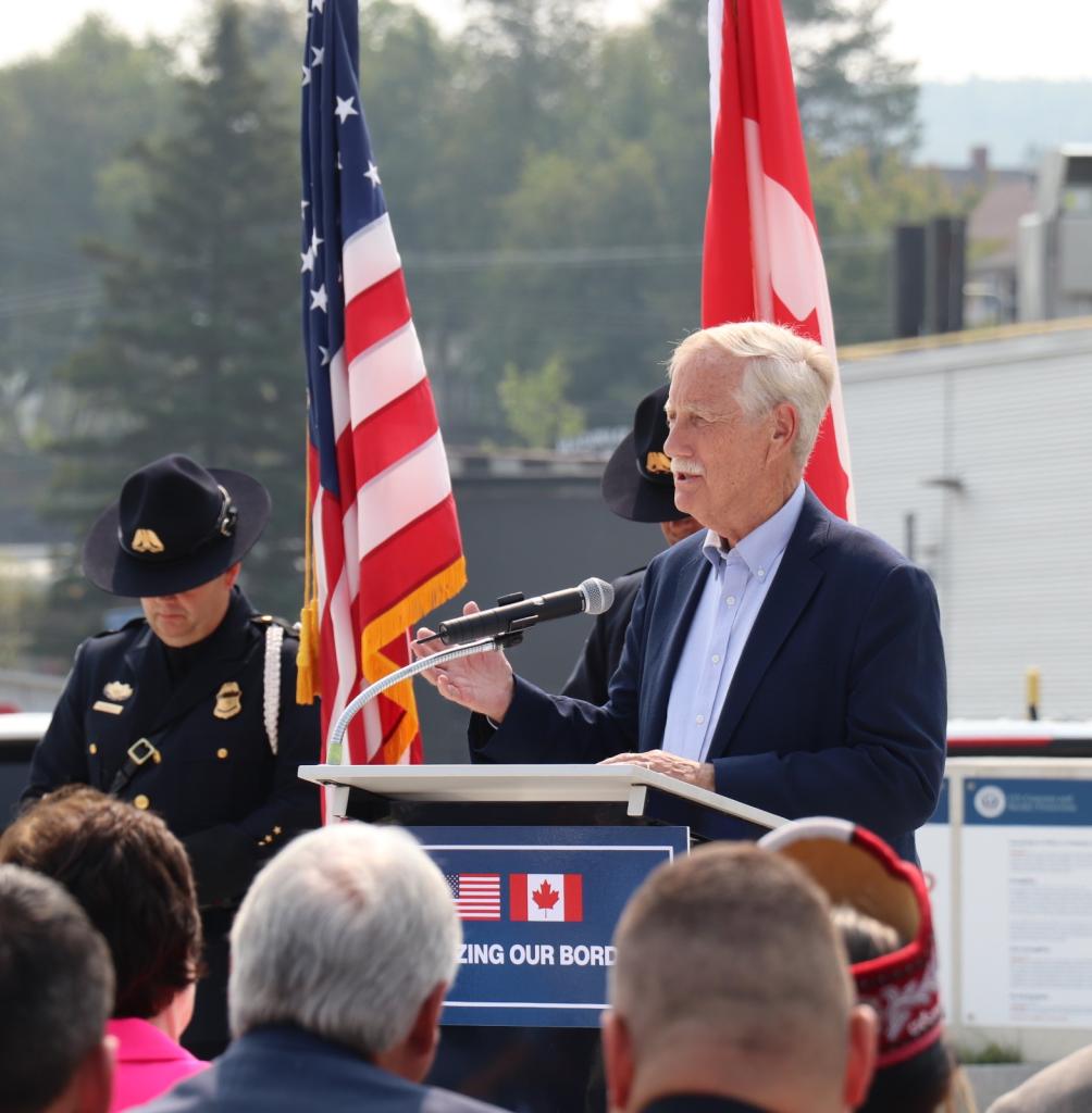 a man in a suit stands at the podium