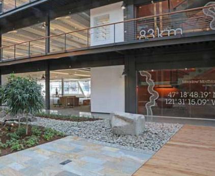 Photo of the "source stone" water feature in the atrium which connects the interior to the Duwamish Waterway.