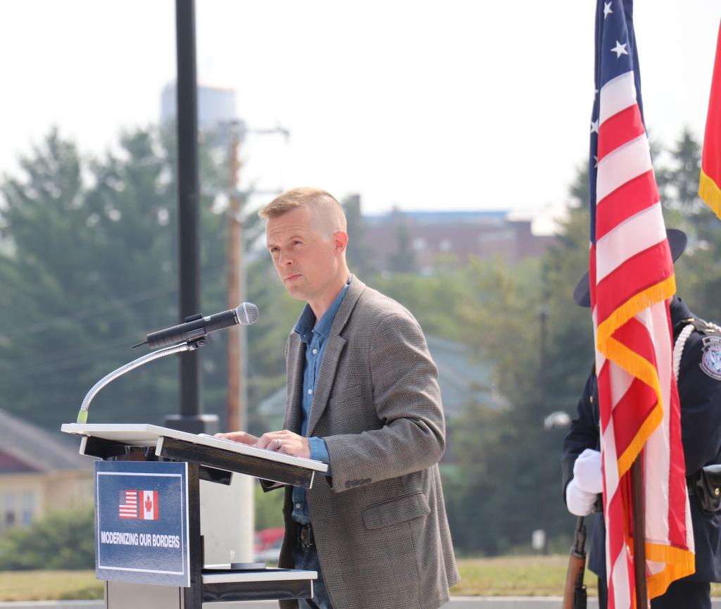 A man in a suit stands at the podium