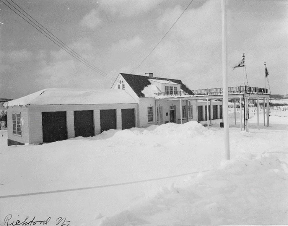 Black and white photos showing the building covered in snow. 